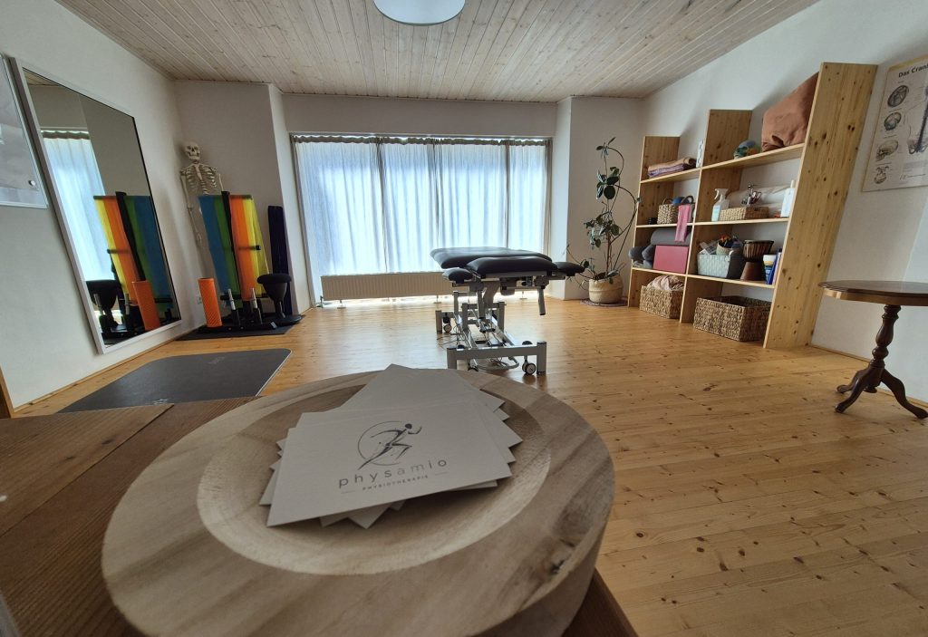 Blick auf die Visitenkarten und dem Therapieraum der Praxis physamio